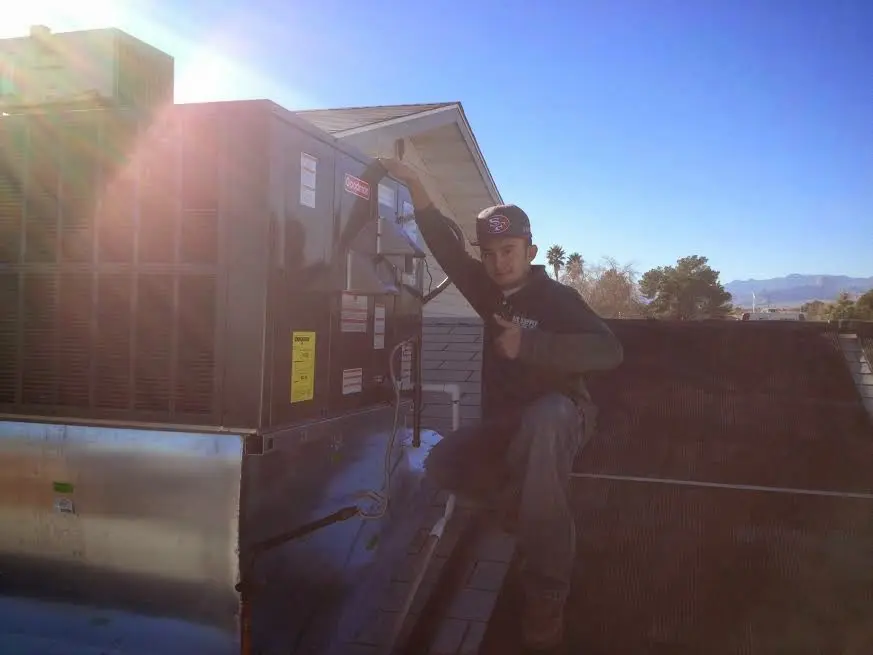 HVAC technician performing Boiler Repair on a rooftop unit in Franklin